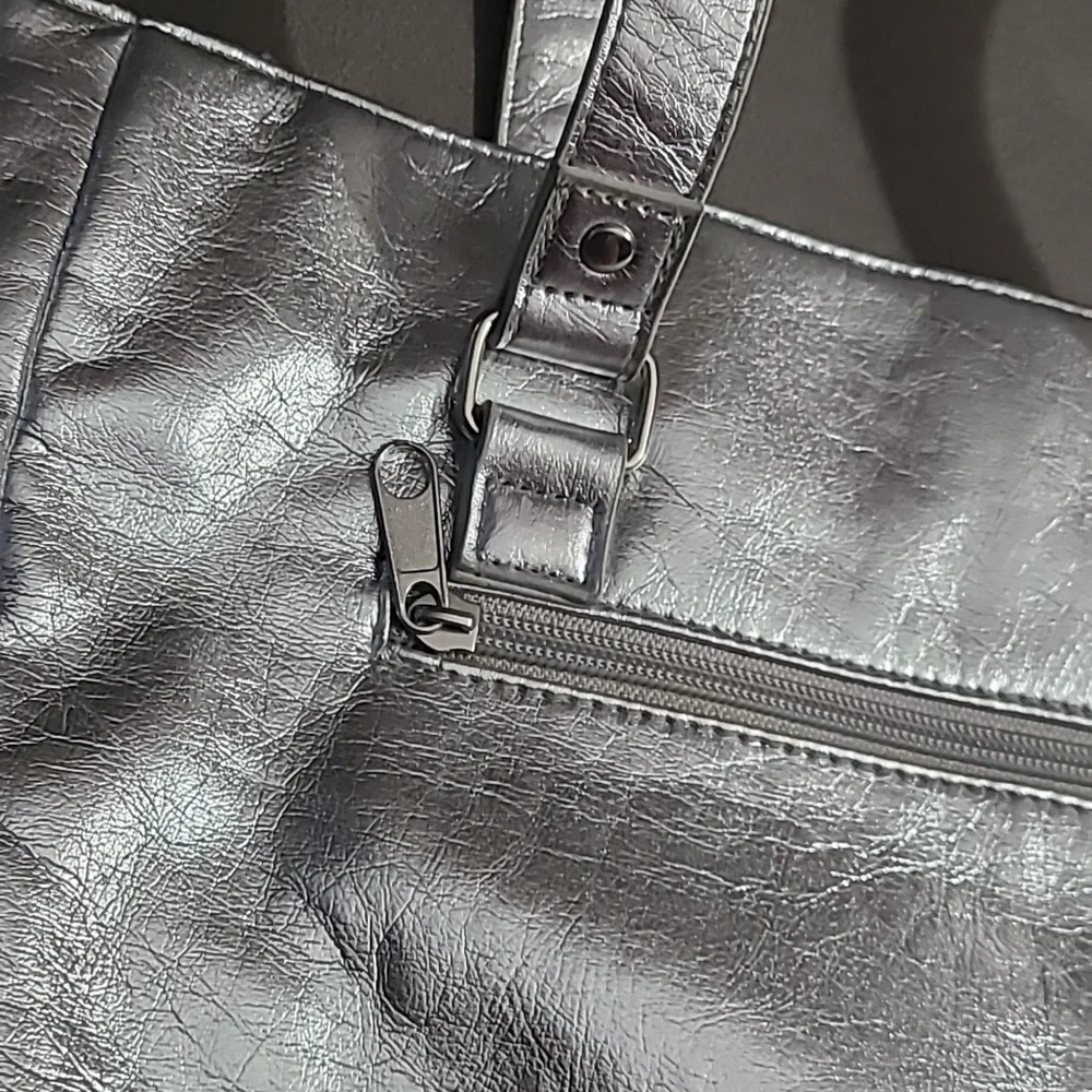 Shiny silver metallic handbag. Outside pockets snap closure‎ clean inside